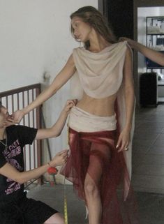 a woman is measuring another woman's waist with tape