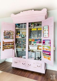 a pink cabinet filled with lots of crafting supplies