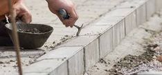 a man is working with cement on the ground