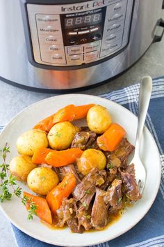 a white plate topped with meat and potatoes next to an instant pot roaster oven