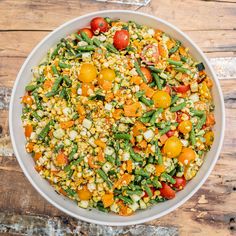 a white bowl filled with vegetables on top of a wooden table