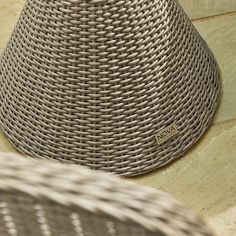 a wicker lamp shade sitting on top of a stone floor