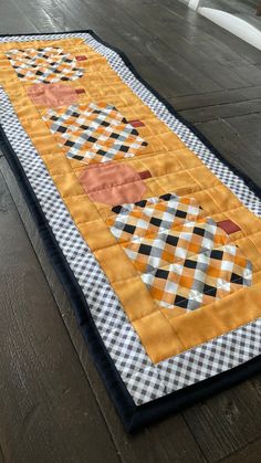 an orange and black table runner on the floor