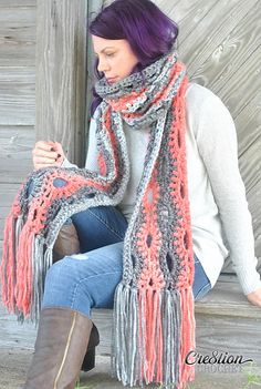 a woman sitting on a bench wearing a scarf and boots