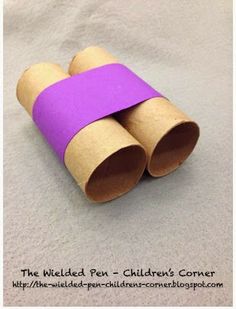 two rolled up toilet paper tubes sitting on top of a sheet of white paper with purple tape