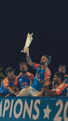 a group of men standing next to each other holding up a trophy