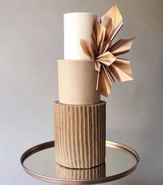 there is a three tiered cake with paper flowers on it