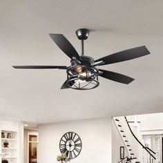 a living room with white walls and black ceiling fan in it's centerpiece