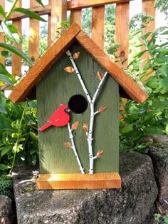 a bird house with a red cardinal on it