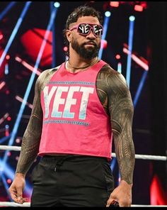 a man with tattoos on his arms and chest wearing a pink shirt that says yeet