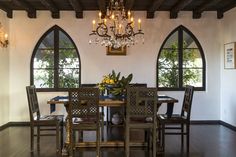 a dining room table with chairs and a chandelier hanging from it's ceiling