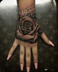 a woman's hand with a rose tattoo on it and the words memento written in cursive writing