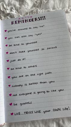 an open notebook with writing on it and pink hearts in the bottom right hand corner