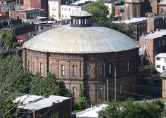 an old building with a dome on top in the middle of a small town area