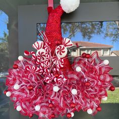 a red and white wreath hanging on the front door