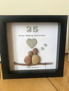 a black frame with some rocks and a heart on it that says 25 silver wedding anniversary