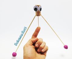 a hand holding a stick with two eyes on it