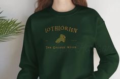 a woman wearing a green sweatshirt with the golden wood logo on it