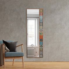 an empty room with a chair, window and wall hanging on the wall in front of it