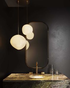 a bathroom vanity with two lights hanging over it