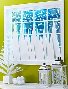 a white christmas tree sitting on top of a mantle next to a window covered in snow