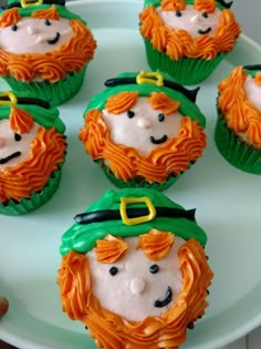 cupcakes with frosting decorated like leprechauns on a plate