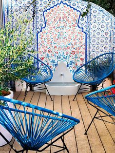 blue chairs are sitting on a wooden deck