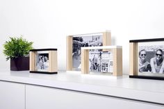 three frames are sitting on top of a white shelf next to a potted plant