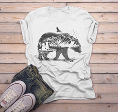 Men's Hipster T Shirt Bear Shirts Camping TShirt Double Exposure Mountains Nature Shirts This double exposure camping tshirt is just awesome to look at. This hipster t shirt features a large bear with a nature scene of mountains, forest, and even two bear cubs double exposed in the silhouette. It also features florals and soaring bird. A perfect tee for your next camping trip, hike or just because it is just cool. Made of soft ring spun cotton and includes a cotton muslin drawstring gift bag. Di White Graphic Print Shirt For Camping, Casual White T-shirt For Hiking, Camping Tshirt, Hipster Tshirts, Mountains Forest, Hipster Man, Nature Shirts, Bear Shirt, Bear Cubs