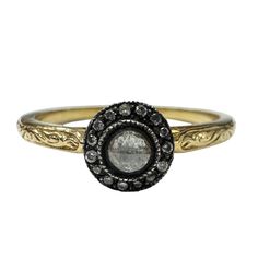 a close up of a ring with an oval stone in the middle and small black diamonds around it