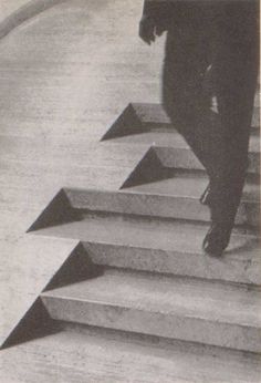 an old photo of a man walking up some stairs with his foot on the steps