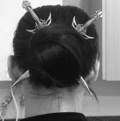 a woman with hair pins in her hair is looking at the mirror and has scissors on her head