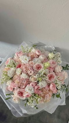 a bouquet of pink and white flowers sitting on top of a table