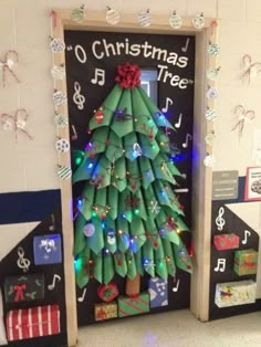 a christmas tree made out of rolled up wrapping paper in front of a classroom door