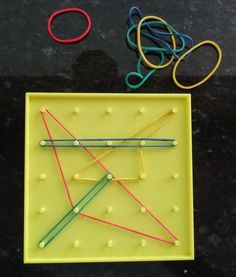 an array of different colored pins and string on a yellow tray