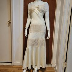 This Exquisite Nightgown Designed By Fernando Sanchez Evokes Old Hollywood Glamour. Adorned With Delicate Lace Cups And Panels, The Gown Boasts A Graceful Mermaid Silhouette And Is Crafted From A Silk Blend. Sized At 12, It Is In Good Vintage Condition, With Only Minor Imperfections Such As A Small Snag And Faint Marks Around The Waist, As Depicted In The Images. Cream Lace Wedding Nightgown, Wedding Cream Lace Nightgown, Cream Lace-trim Sleepwear For Wedding, Cream Wedding Sleepwear With Lace Trim, White Bias Cut Slip Dress For Sleep, Fitted Cream Nightgown For Wedding, Cream Lace Sleepwear For Wedding Night, Fitted White Gown For Sleep, Fitted White Sleep Gown