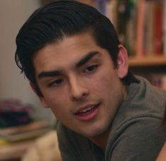 a close up of a person with a book in the background