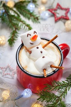 there is a snowman in a mug with cinnamon sticks sticking out of the top