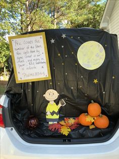 a car trunk filled with pumpkins and other items in front of a sign that reads, he counts the number of the stars