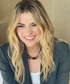 a woman sitting at a table smiling for the camera