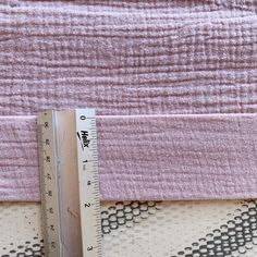 a ruler is sitting next to a pink blanket