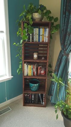 a bookshelf filled with lots of books next to a window in a room