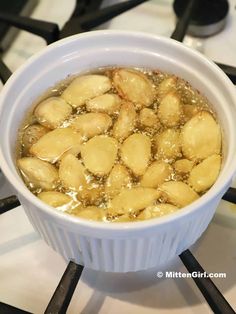 a white bowl filled with food sitting on top of a stove