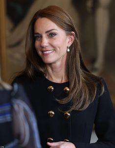 a woman in a black coat talking to another woman