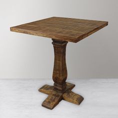 an old wooden table on a white floor with no one around it or in the background