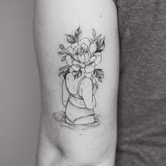 a woman's arm with a flower tattoo on it