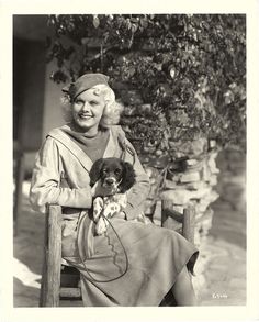 an old black and white photo of a woman sitting on a bench with her dog