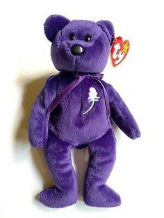 a purple teddy bear with a tag on it's chest and neck is standing upright