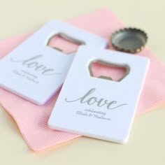 two bottle openers sitting on top of a pink napkin