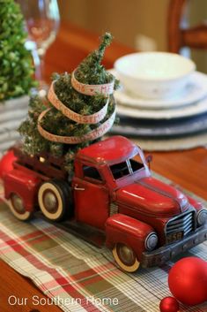 an old red truck with a christmas tree on the back